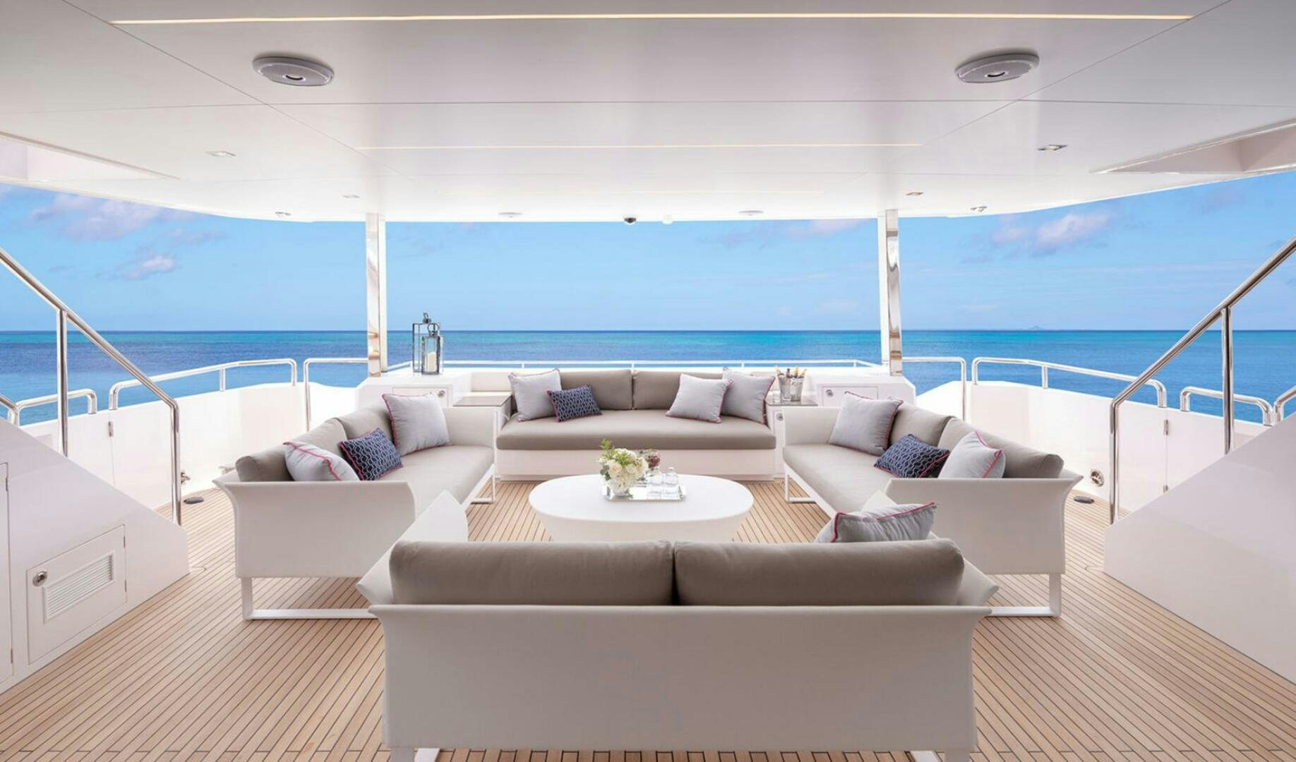 a white living room with a large balcony overlooking the ocean aboard ICE Yacht for Sale