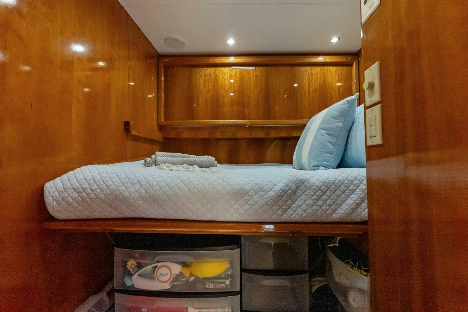 a bed with a white sheet and a blue pillow on it aboard TOUCH N GO Yacht for Sale