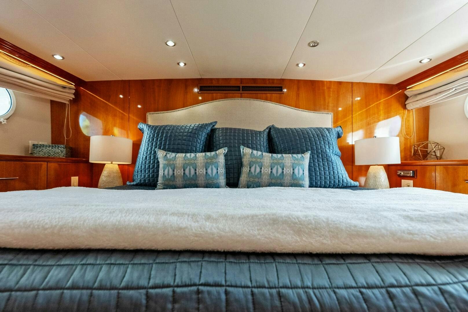 a bed with blue and white sheets aboard TOUCH N GO Yacht for Sale
