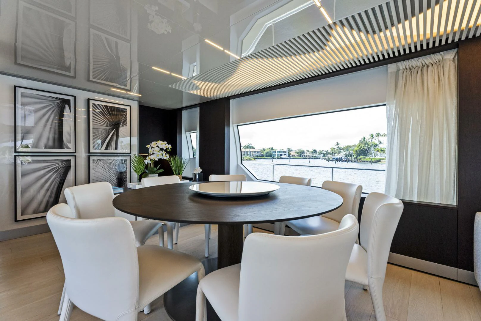a dining table and chairs in a room with a large window aboard PINCH ME Yacht for Sale