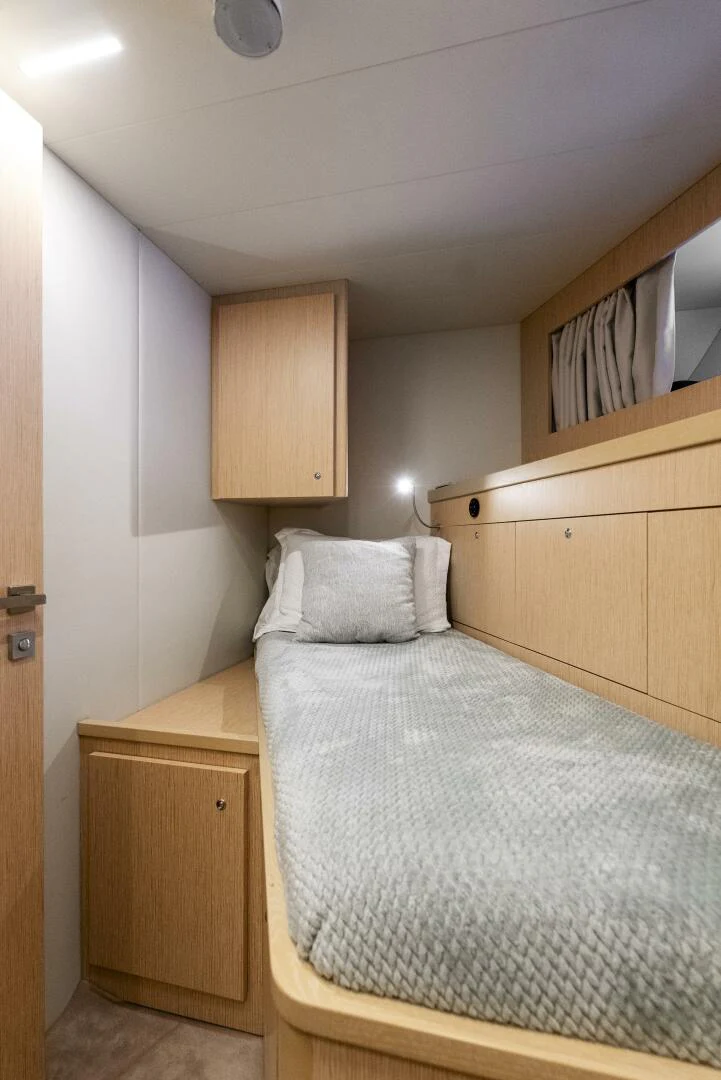 a bedroom with a bed and cabinets aboard PINCH ME Yacht for Sale