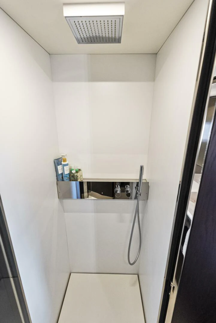 a white bathroom with a black door aboard PINCH ME Yacht for Sale