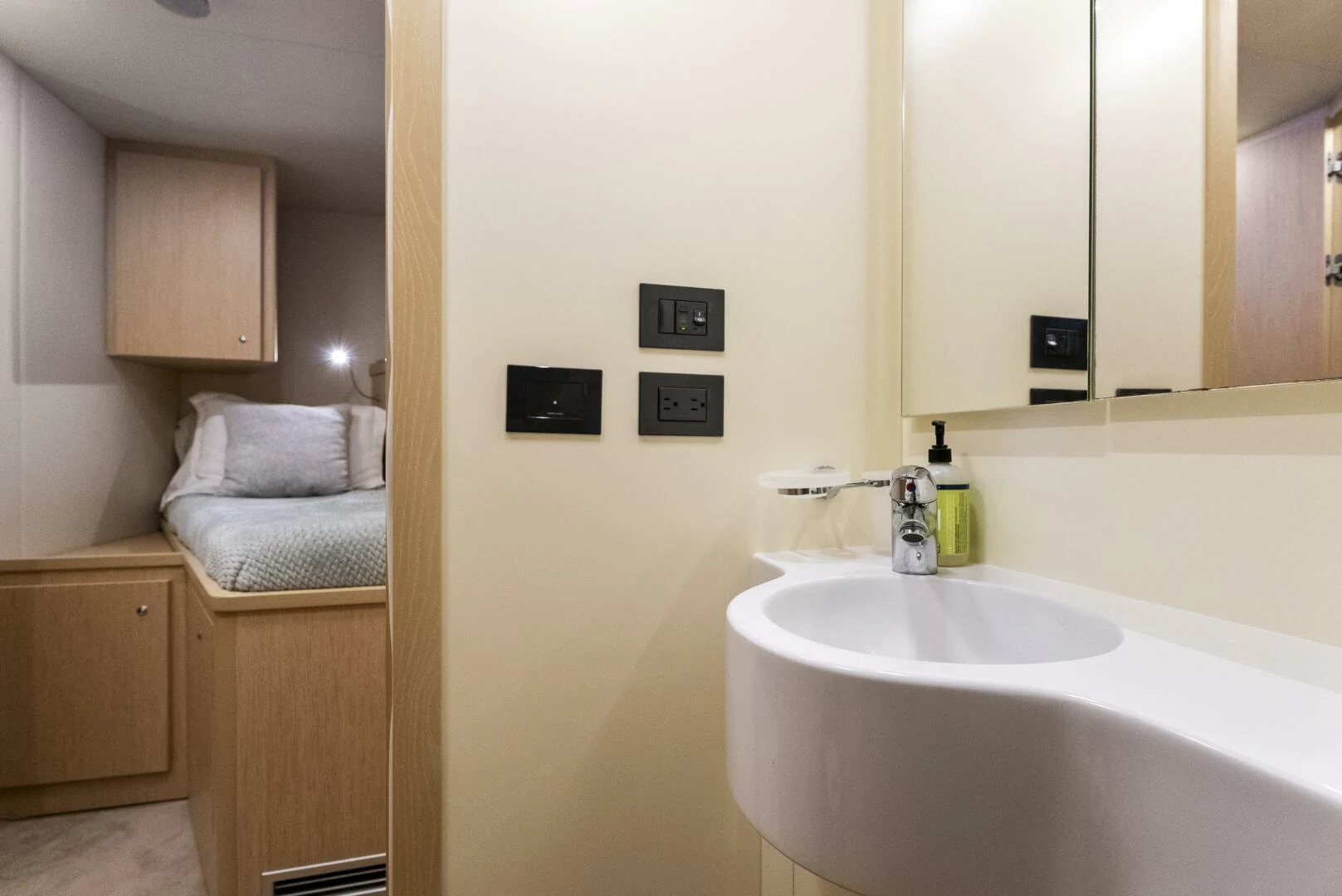 a bathroom with a sink and a bed aboard PINCH ME Yacht for Sale