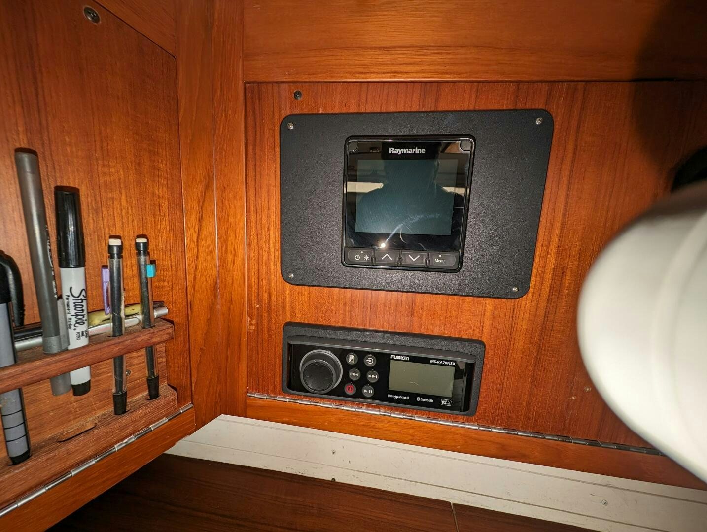 a rectangular electronic device on a wooden surface aboard MOJO Yacht for Sale