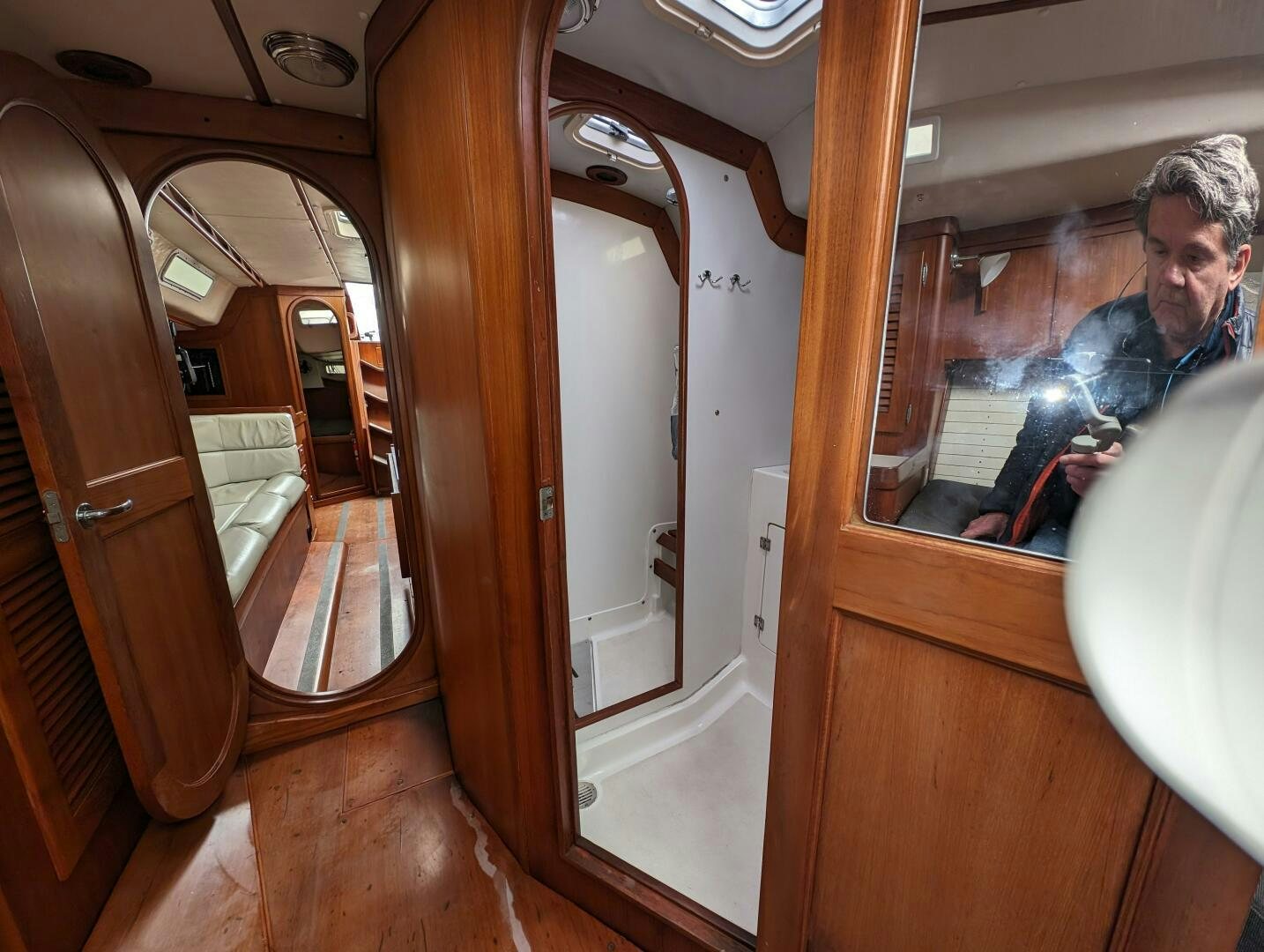 a person taking a picture of himself in a bathroom mirror aboard MOJO Yacht for Sale