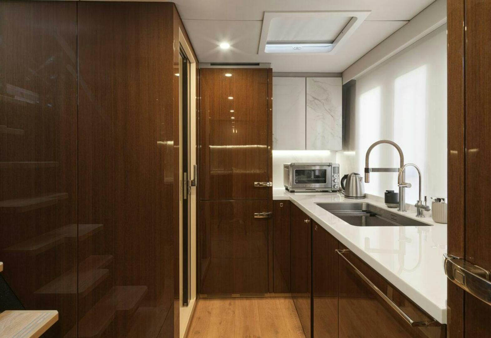 a kitchen with wooden cabinets aboard OV Yacht for Sale