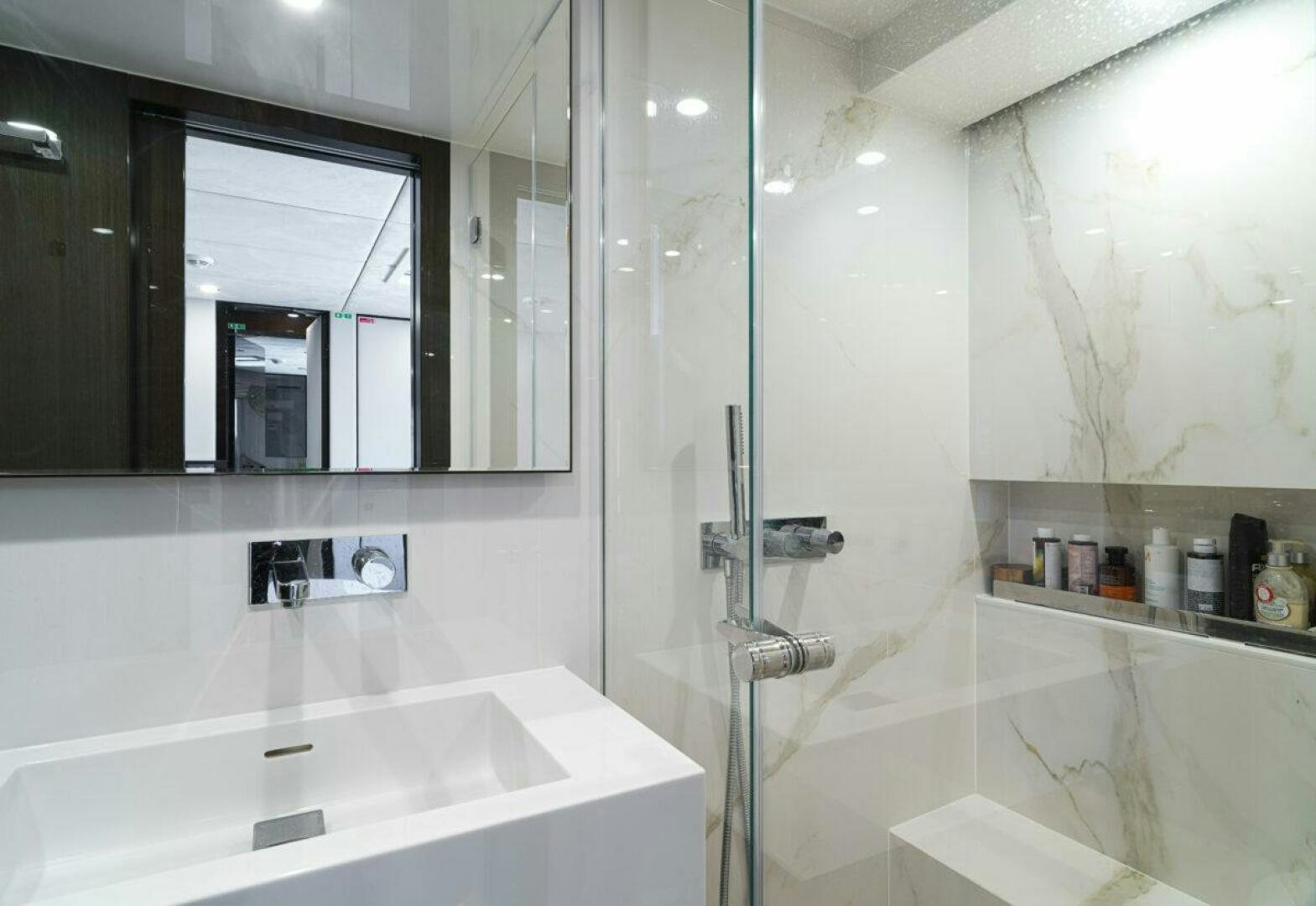 a bathroom with a glass shower aboard OV Yacht for Sale