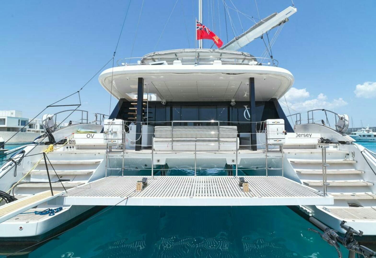 a large white boat with a flag on the front aboard OV Yacht for Sale