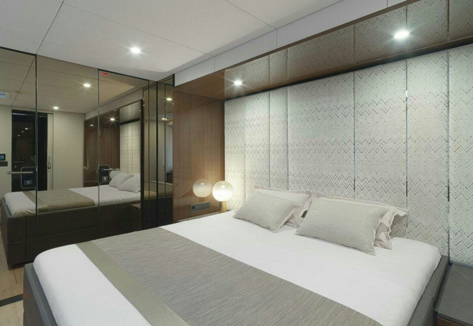 a room with a bed and a mirror aboard OV Yacht for Sale