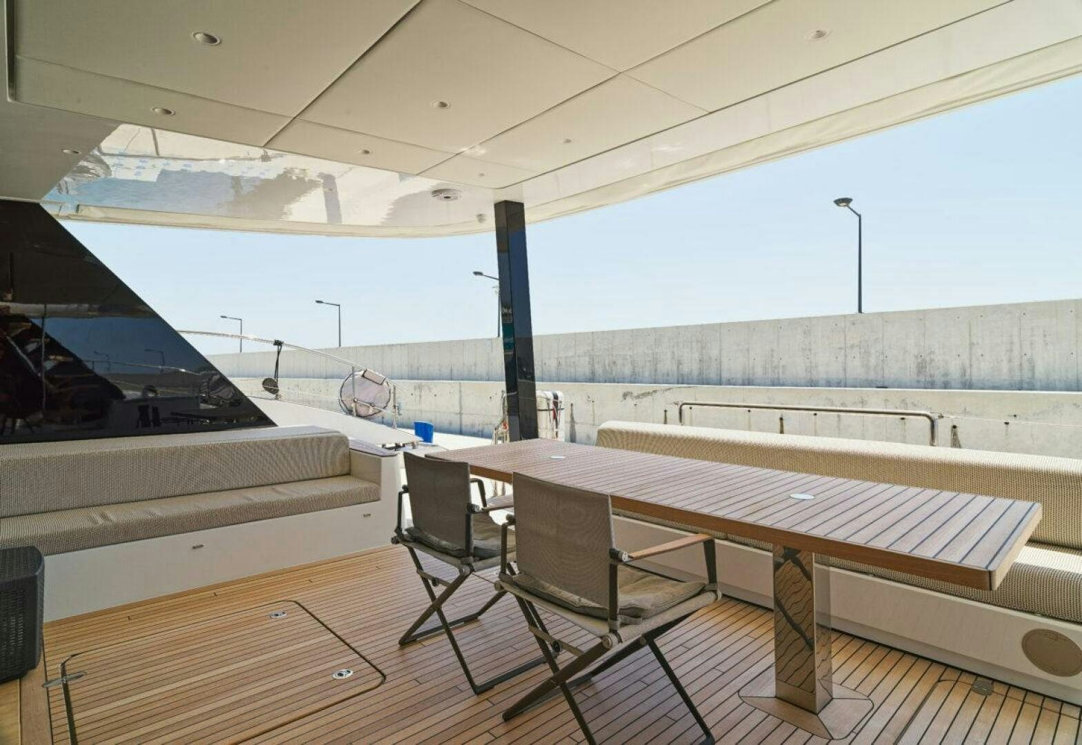a table and chairs on a deck aboard OV Yacht for Sale