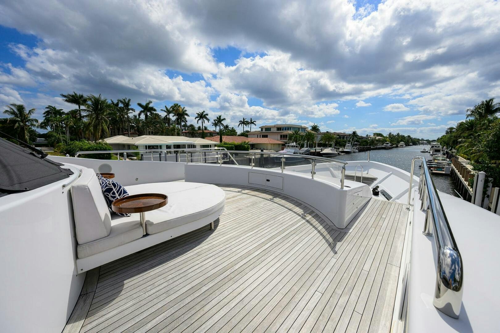 a large white building with a balcony and a pool with trees and blue sky and clouds aboard NEENAH Yacht for Sale