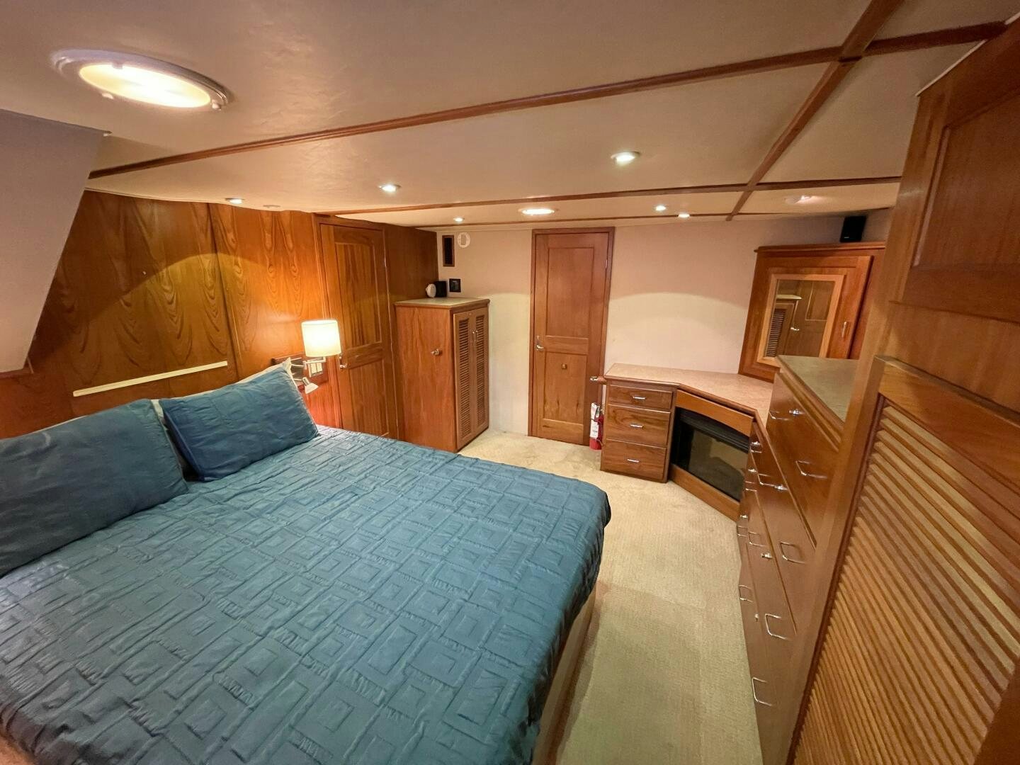 a bedroom with a bed and cabinets aboard TRAVELLER II Yacht for Sale