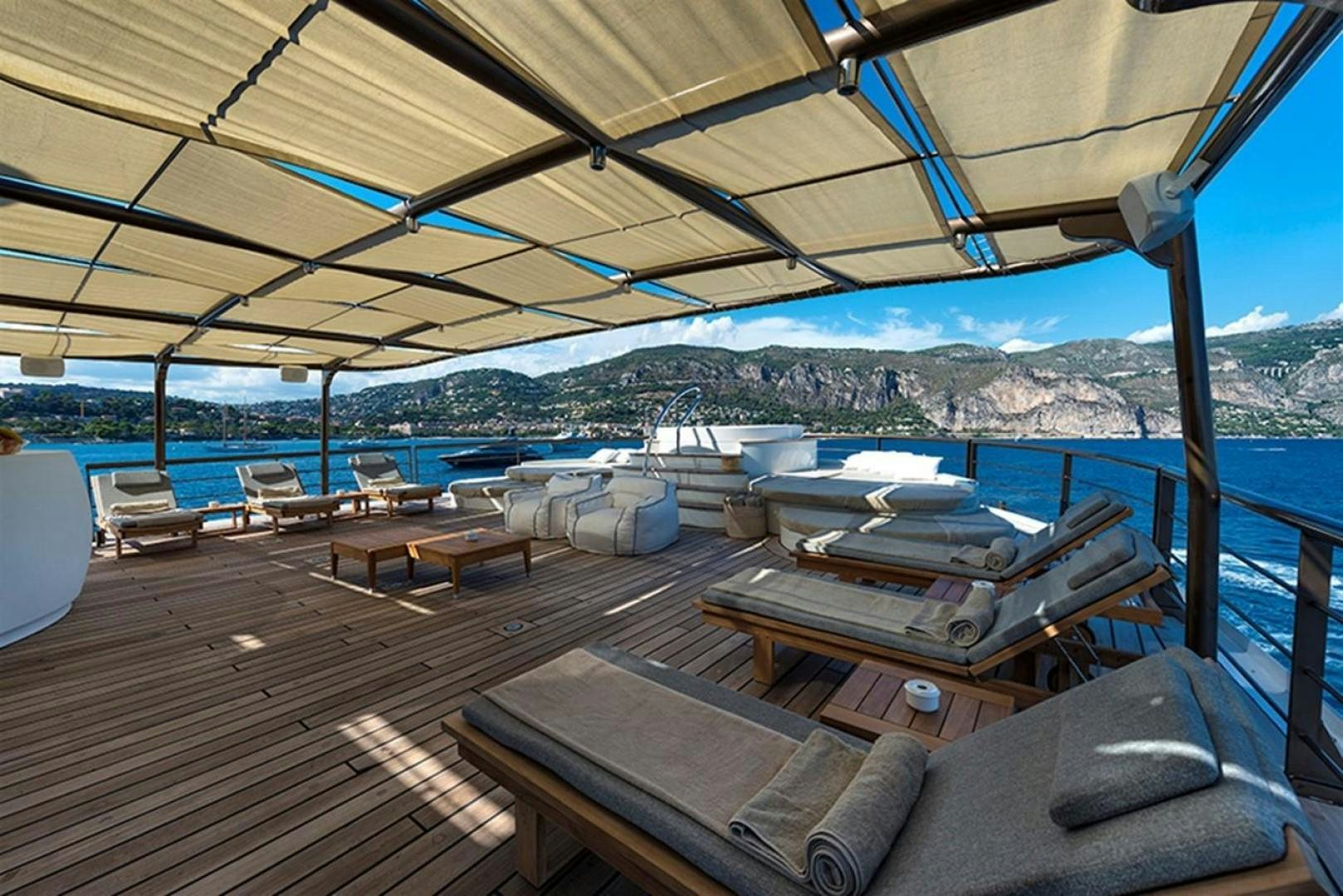 a deck with a large bed and a large body of water aboard CHAKRA Yacht for Sale