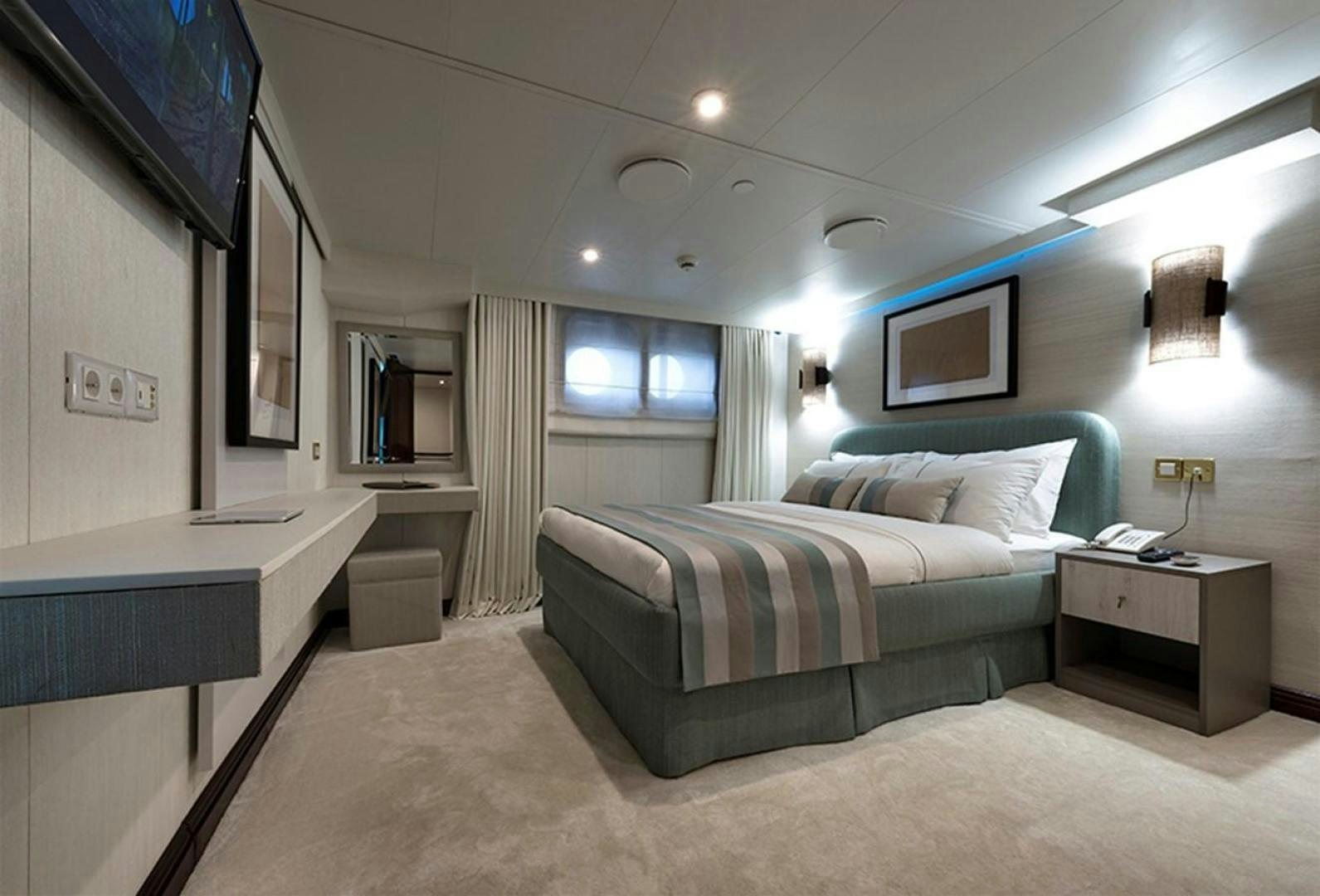 a bedroom with a bed and a desk aboard CHAKRA Yacht for Sale