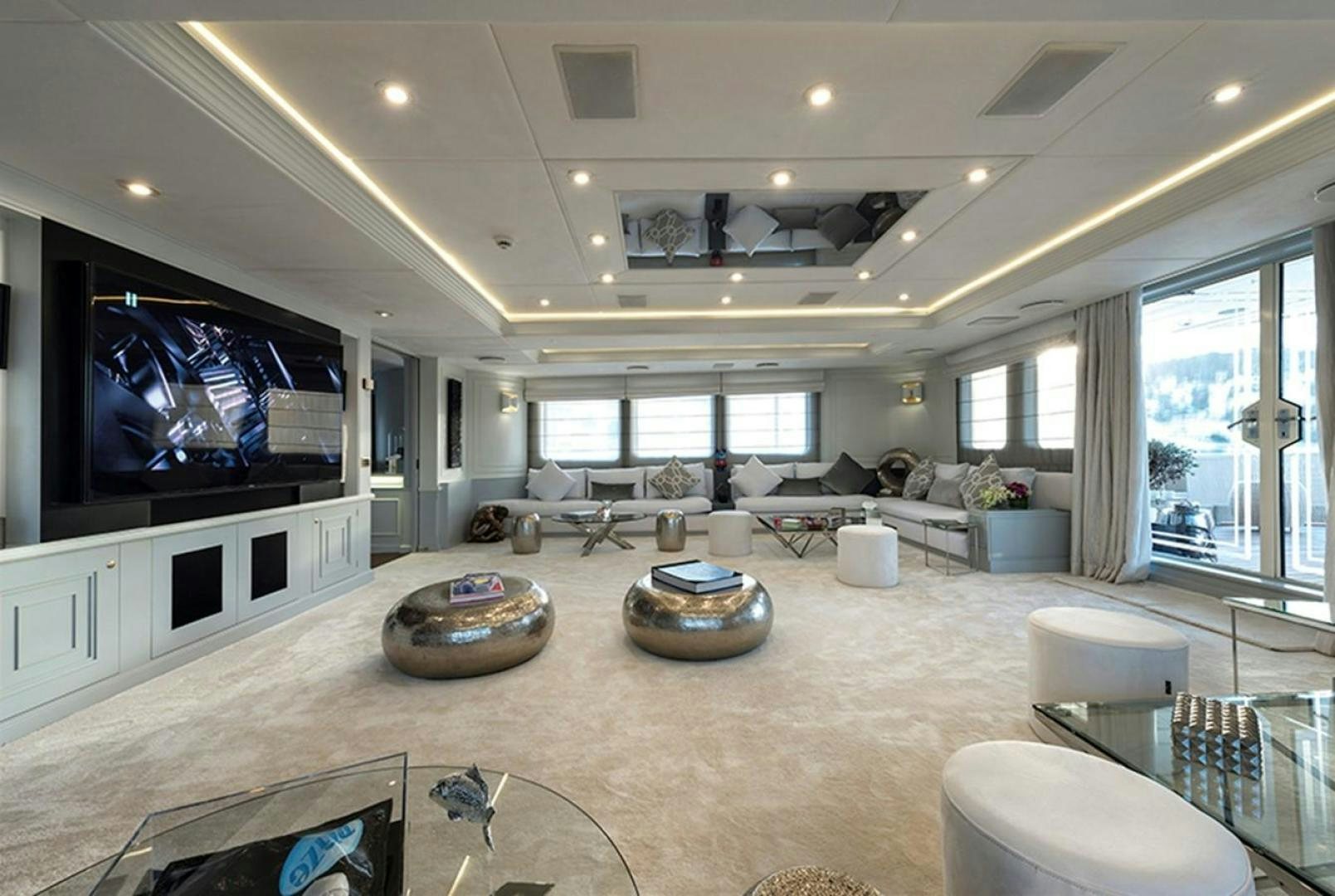 a large living room with a large screen aboard CHAKRA Yacht for Sale