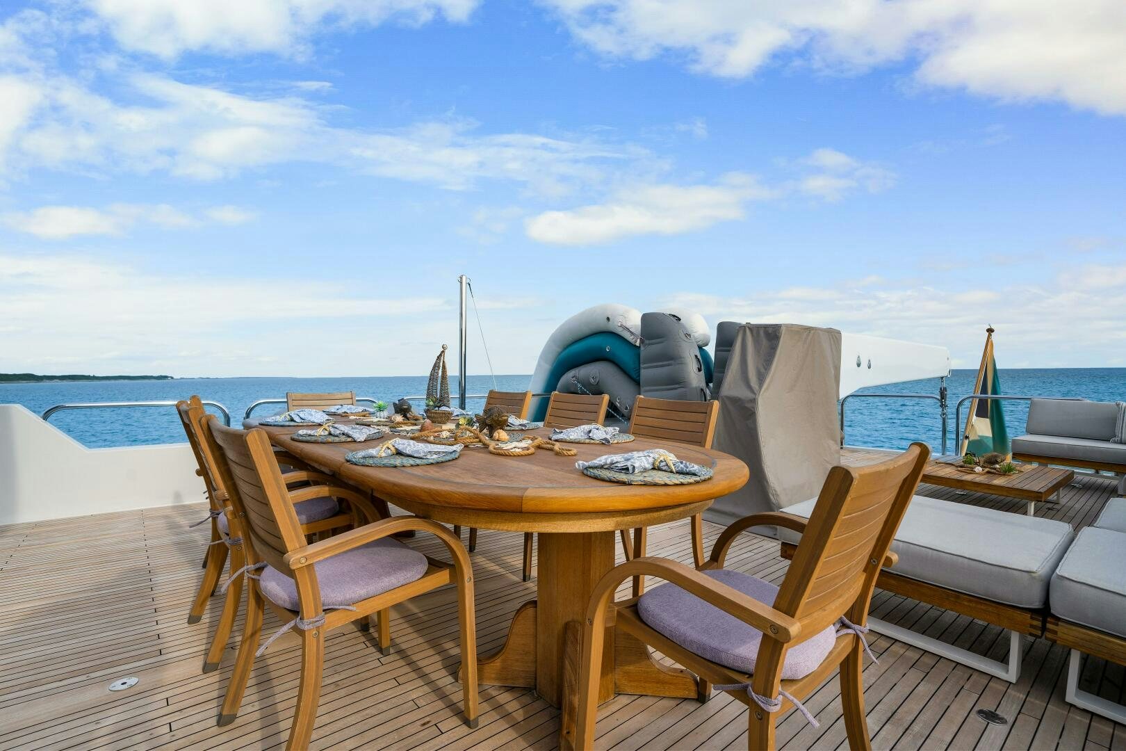 a table and chairs on a deck overlooking the ocean aboard SWEET ESCAPE Yacht for Sale