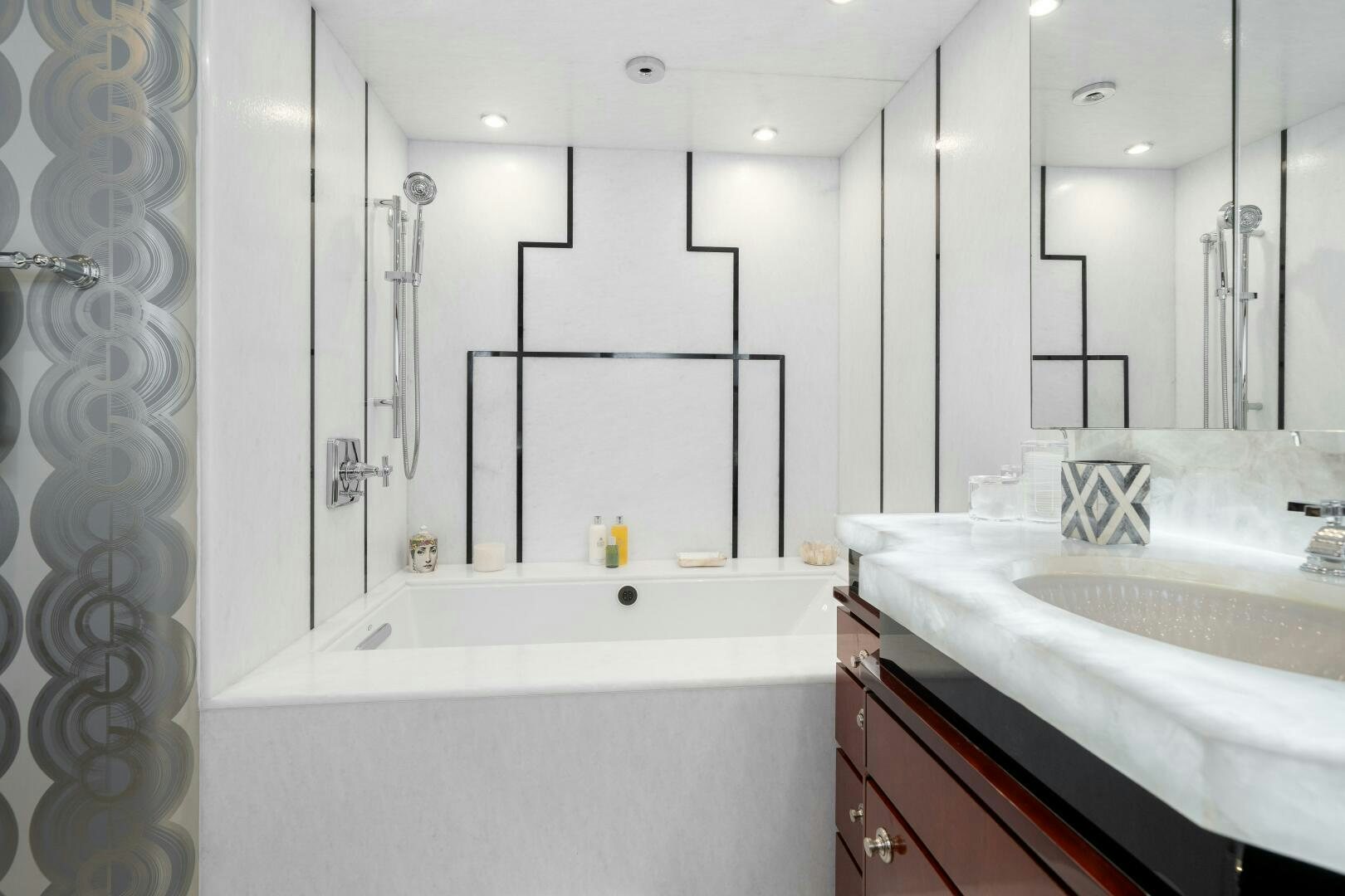 a bathroom with a tub sink and a mirror aboard SWEET ESCAPE Yacht for Sale