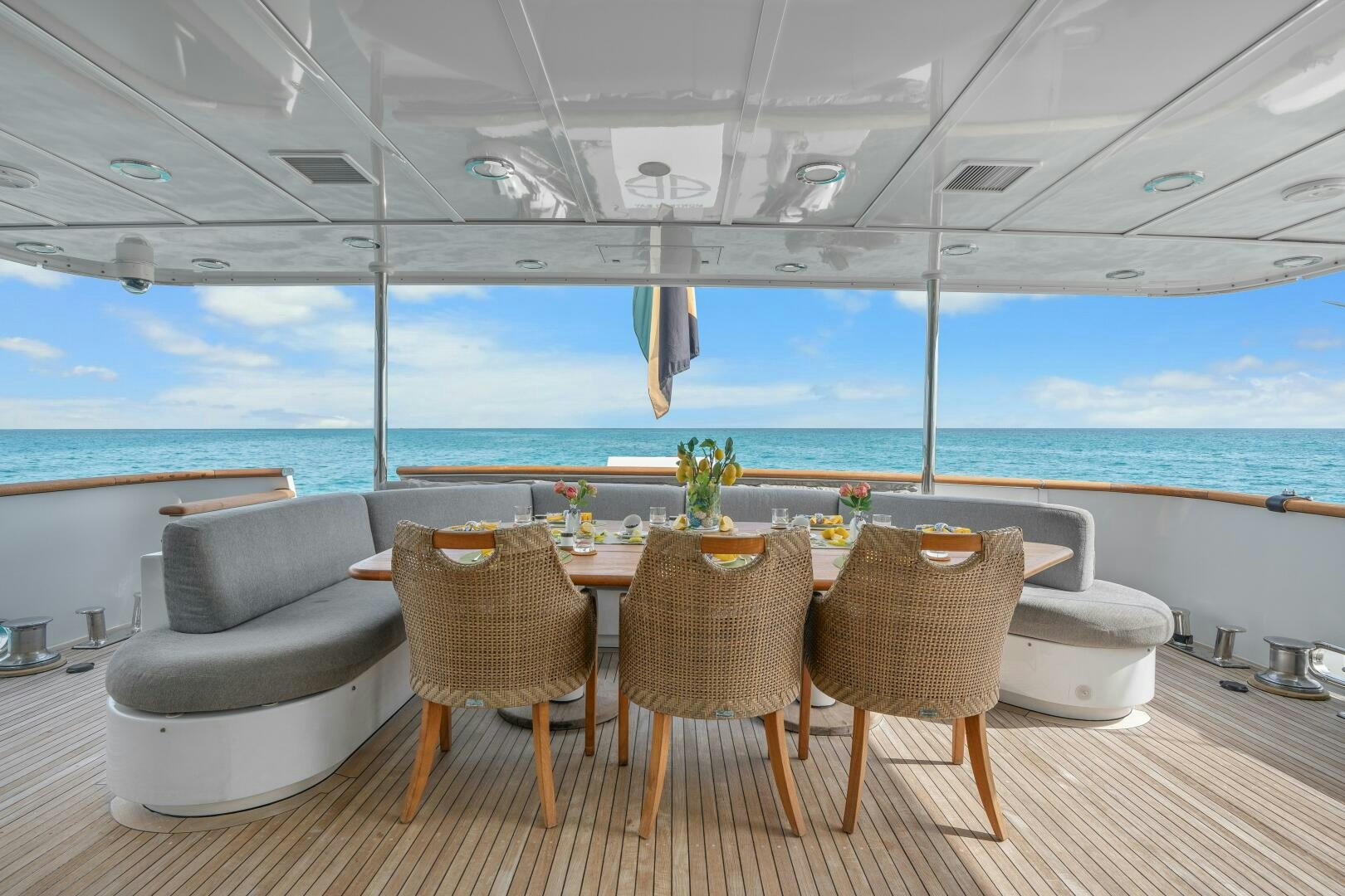 a table set for a meal on a deck overlooking the ocean aboard SWEET ESCAPE Yacht for Sale