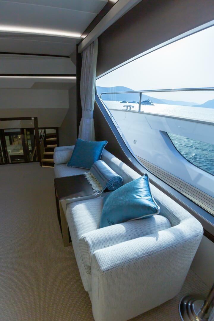 a room with a couch and a table and a large window aboard MR. K IRISTON Yacht for Sale