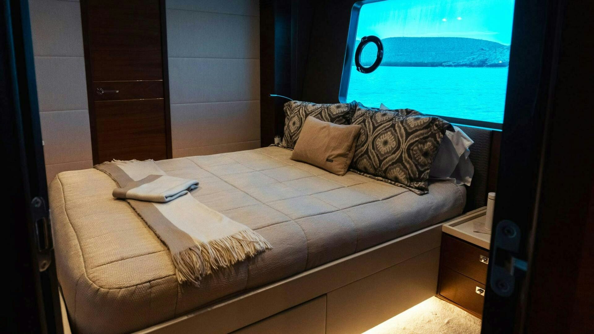 a bed with a pillow and a window aboard SATORI Yacht for Sale