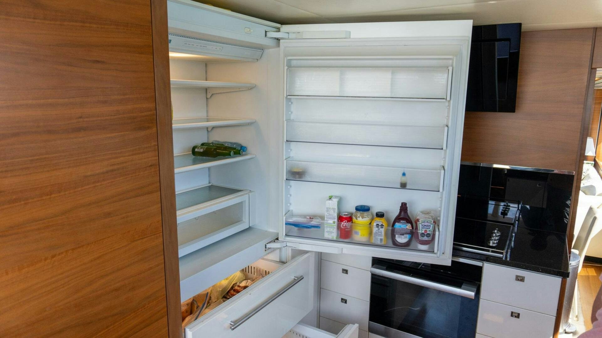a kitchen with a white refrigerator aboard SATORI Yacht for Sale