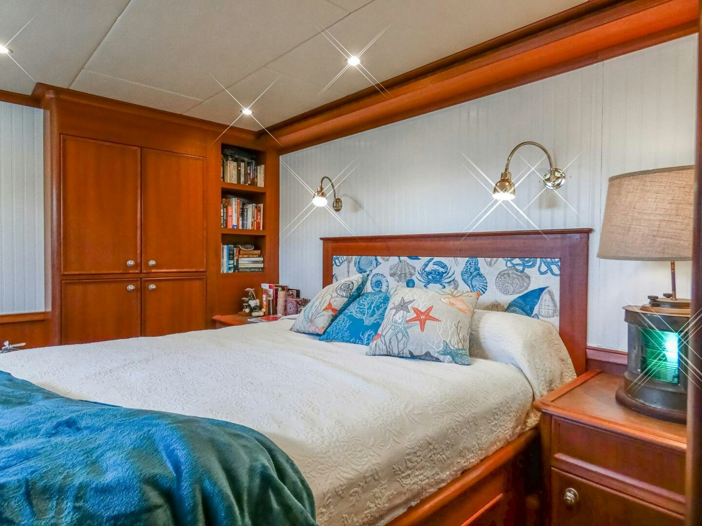 a bedroom with a bed and a bookcase aboard IIWII Yacht for Sale