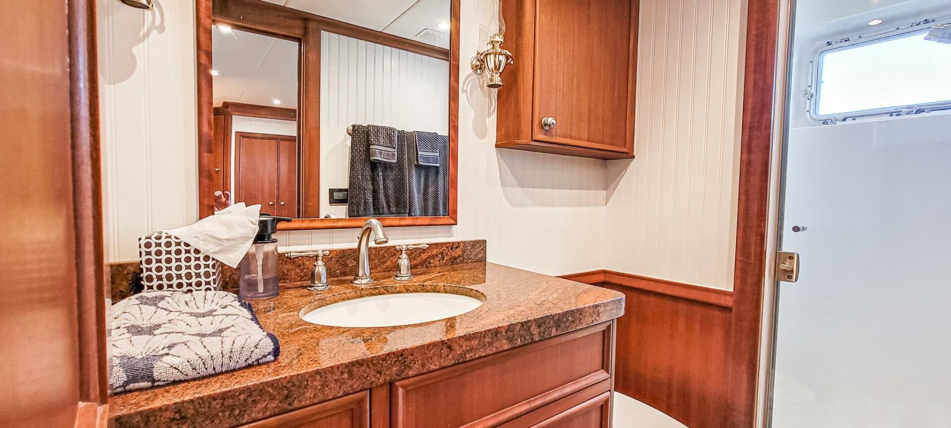a bathroom with a countertop sink and mirror aboard IIWII Yacht for Sale
