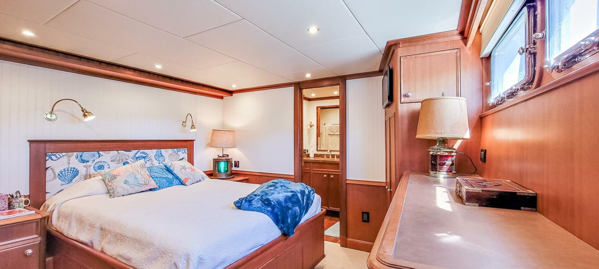 a bedroom with a bed and a desk aboard IIWII Yacht for Sale