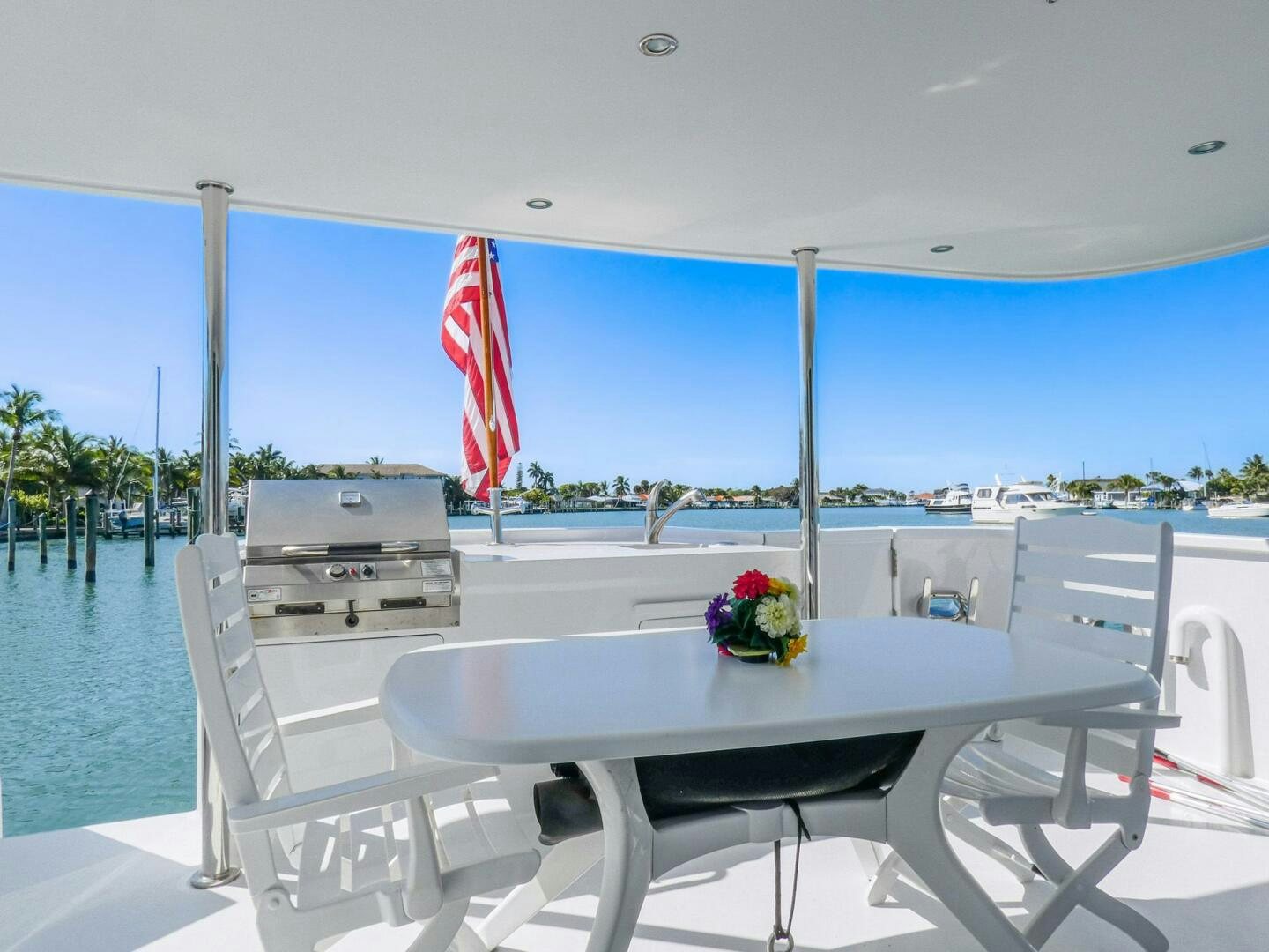 a table and chairs on a deck aboard IIWII Yacht for Sale