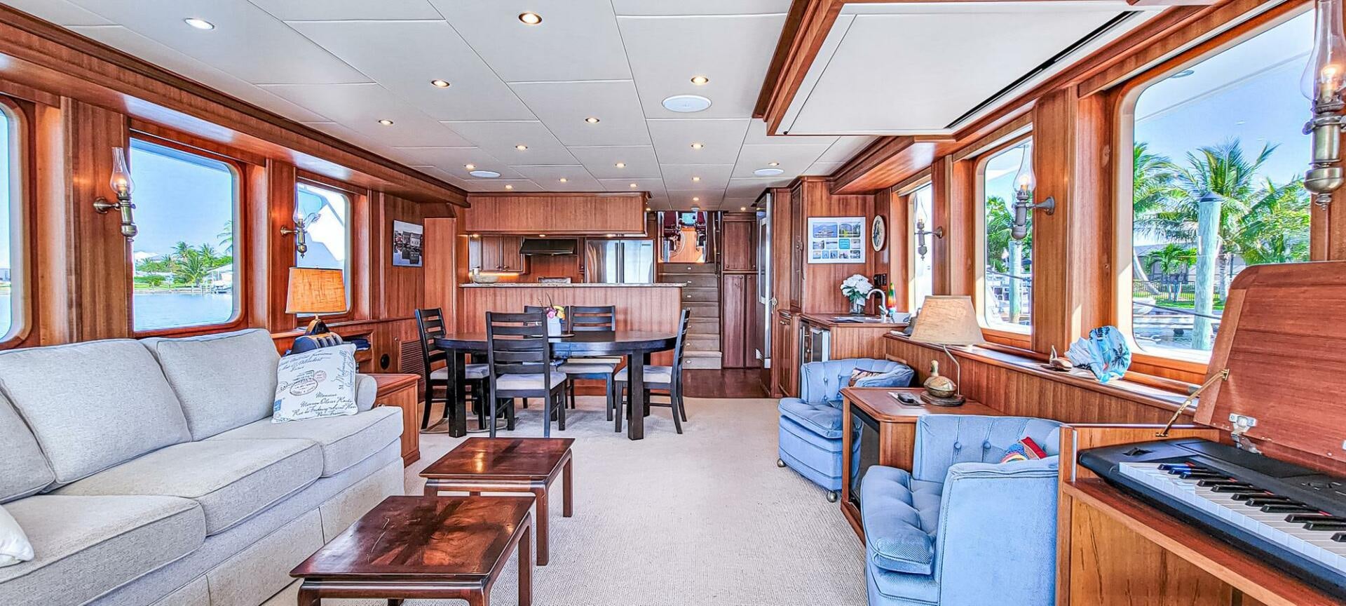 a living room with a piano and a piano aboard IIWII Yacht for Sale