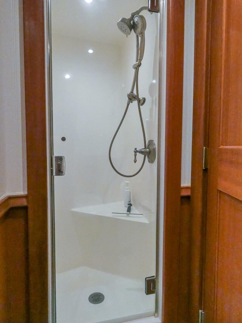 a shower with a sink and a mirror aboard IIWII Yacht for Sale