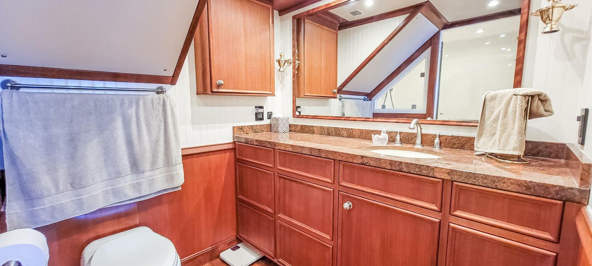 a bathroom with a countertop sink and cabinets aboard IIWII Yacht for Sale