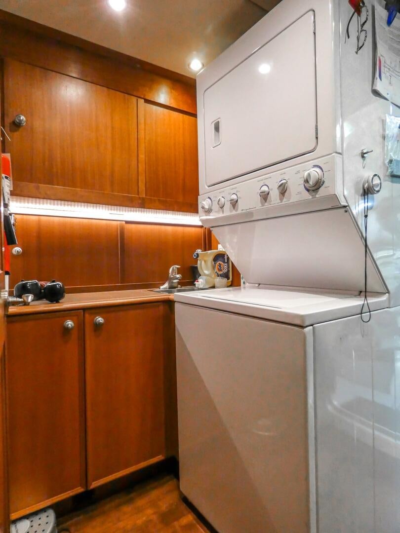 a kitchen with a stainless steel refrigerator aboard IIWII Yacht for Sale