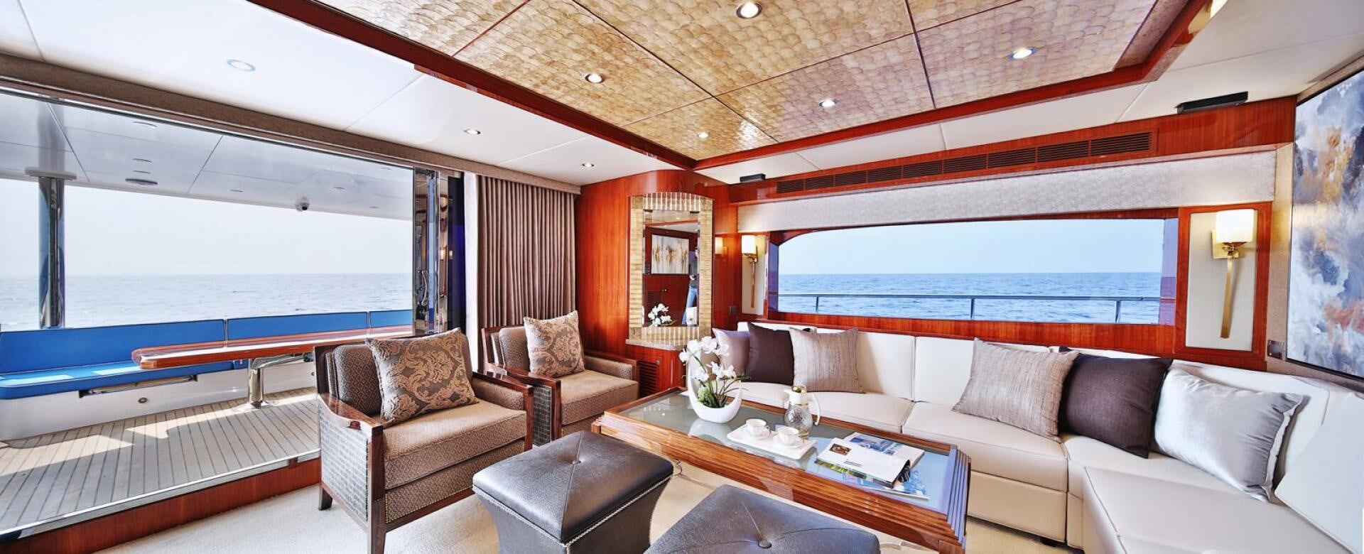 a room with a couch and a table and a large window aboard DEESCOVERY Yacht for Sale