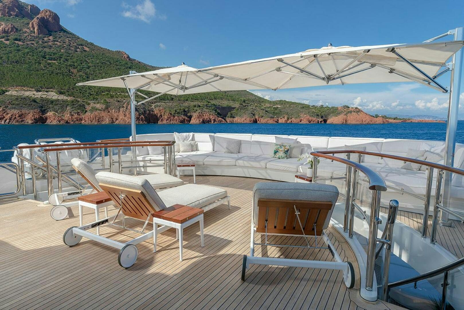 a lounge area on a deck overlooking a body of water aboard FRIENDSHIP Yacht for Sale