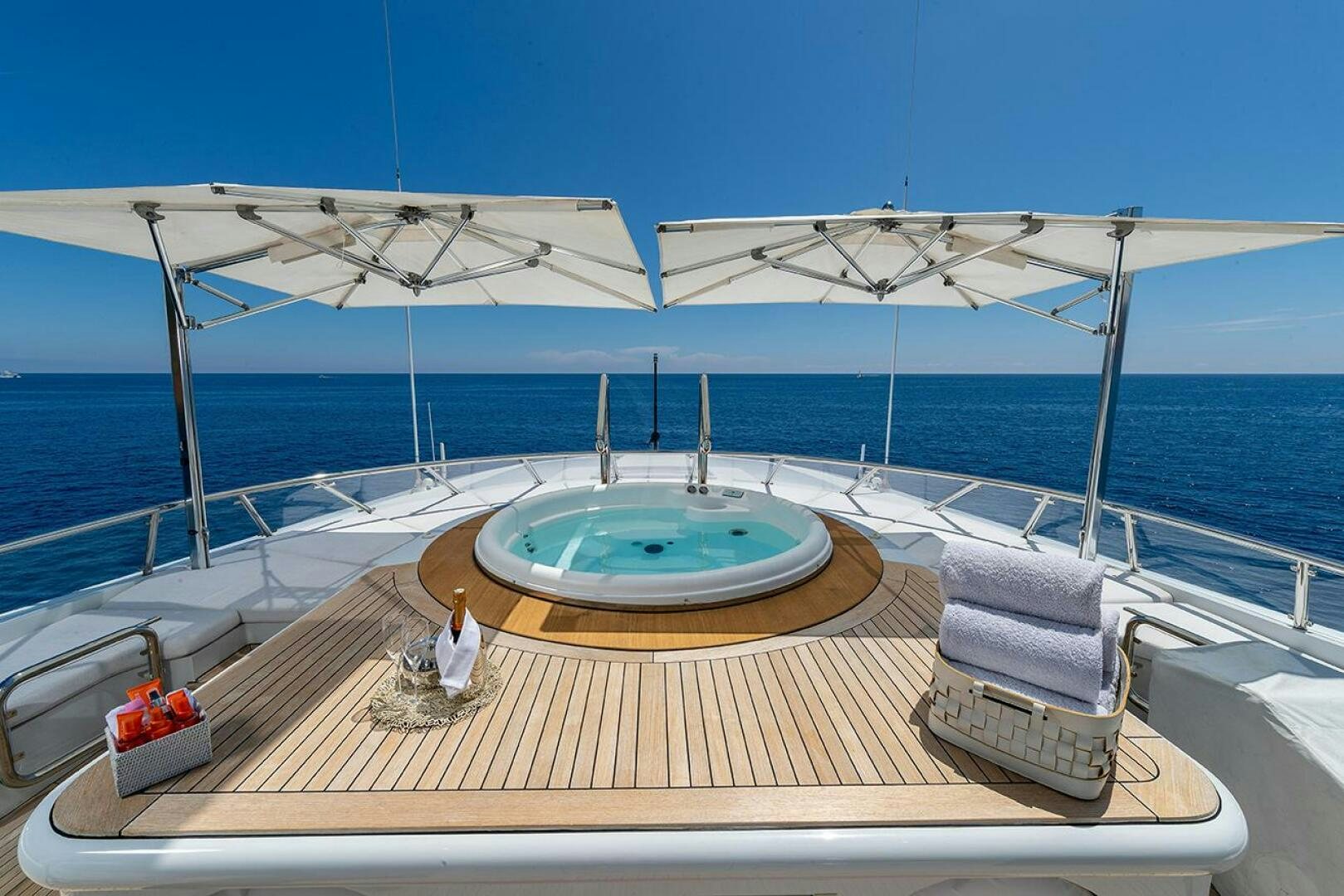 a deck with a large pool and a large umbrella on it aboard FRIENDSHIP Yacht for Sale