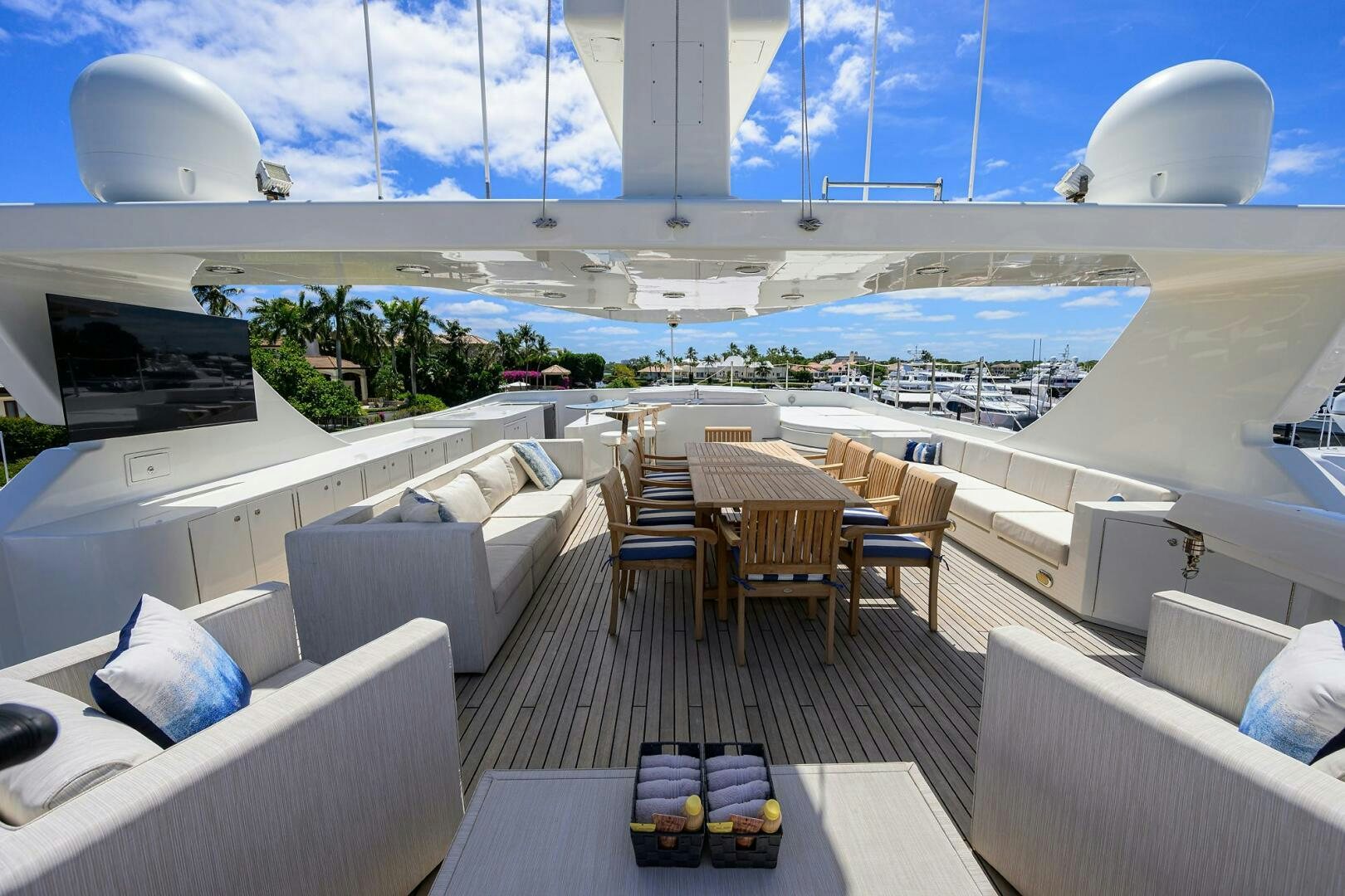 a room with a table chairs and a large white building with a pool aboard KIMBERLIE Yacht for Sale