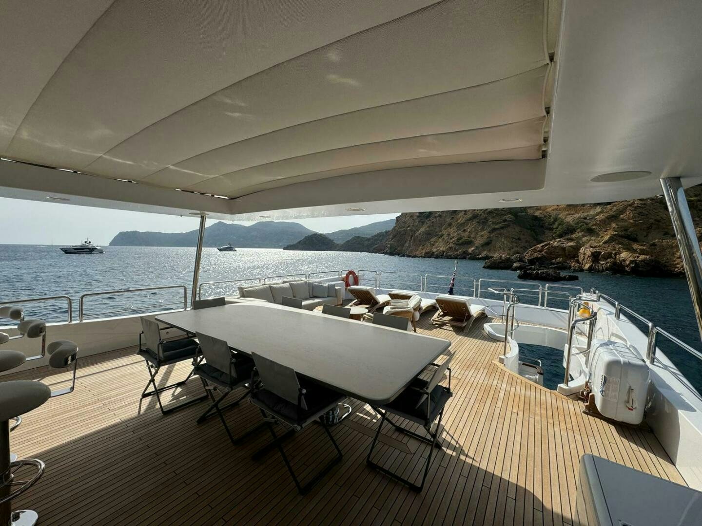 a deck with a table and chairs on it aboard SERENDIPITY Yacht for Sale