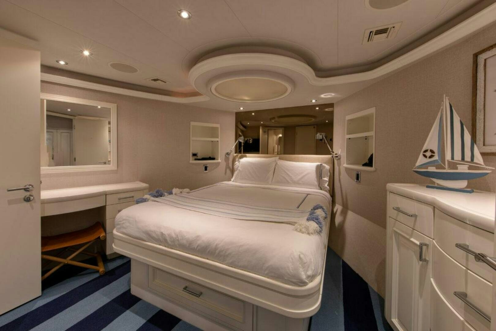 a bedroom with a bed and a mirror aboard BOXER Yacht for Sale