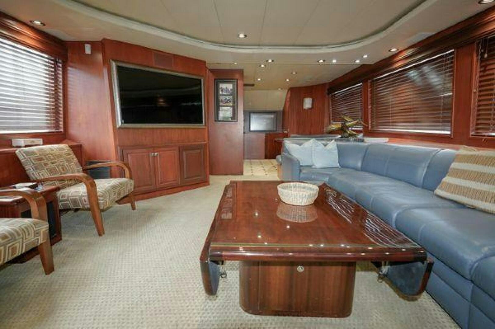 a living room with a table and couches aboard POLE POSITION Yacht for Sale