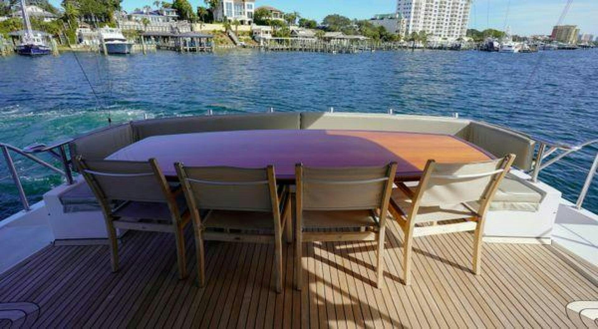 a table and chairs on a deck by a body of water aboard POLE POSITION Yacht for Sale