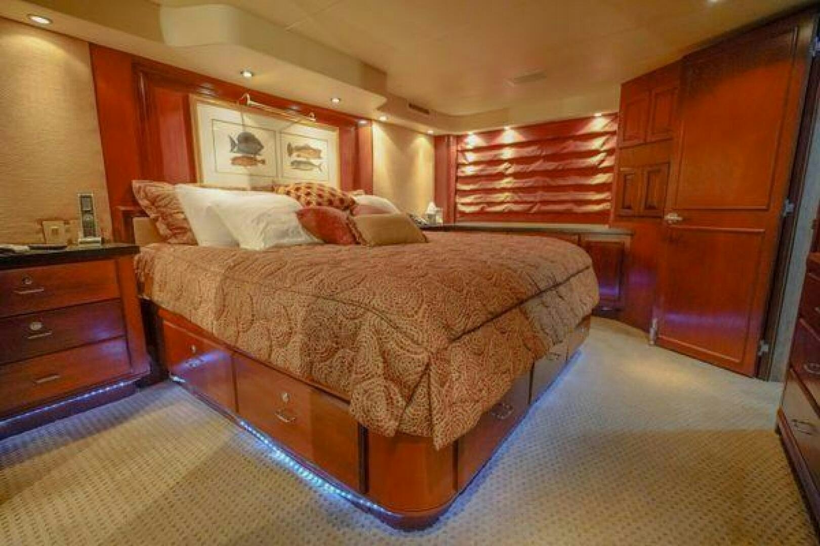 a bedroom with a bed and dresser aboard POLE POSITION Yacht for Sale