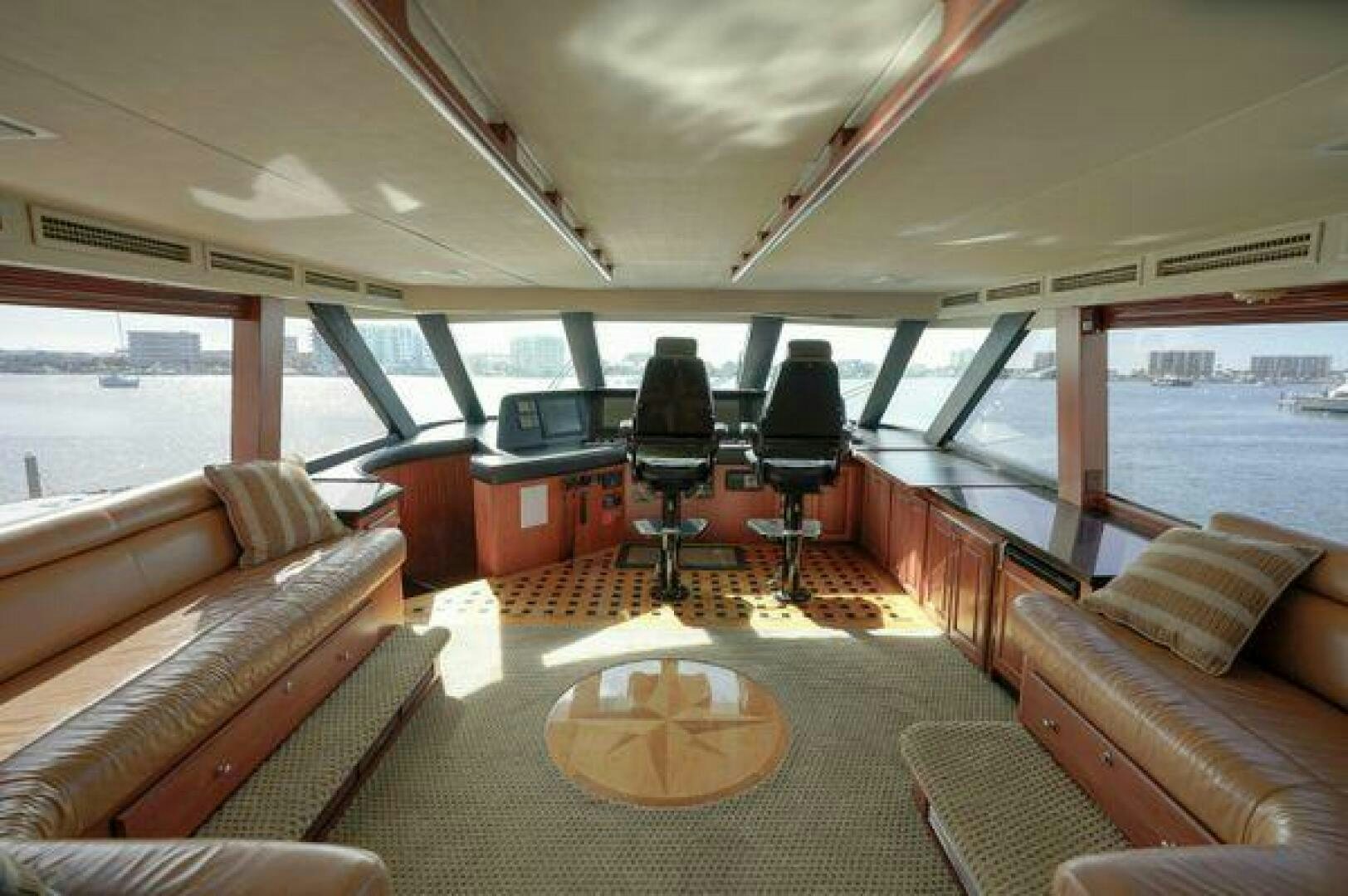 a room with a couch and a table and a window aboard POLE POSITION Yacht for Sale