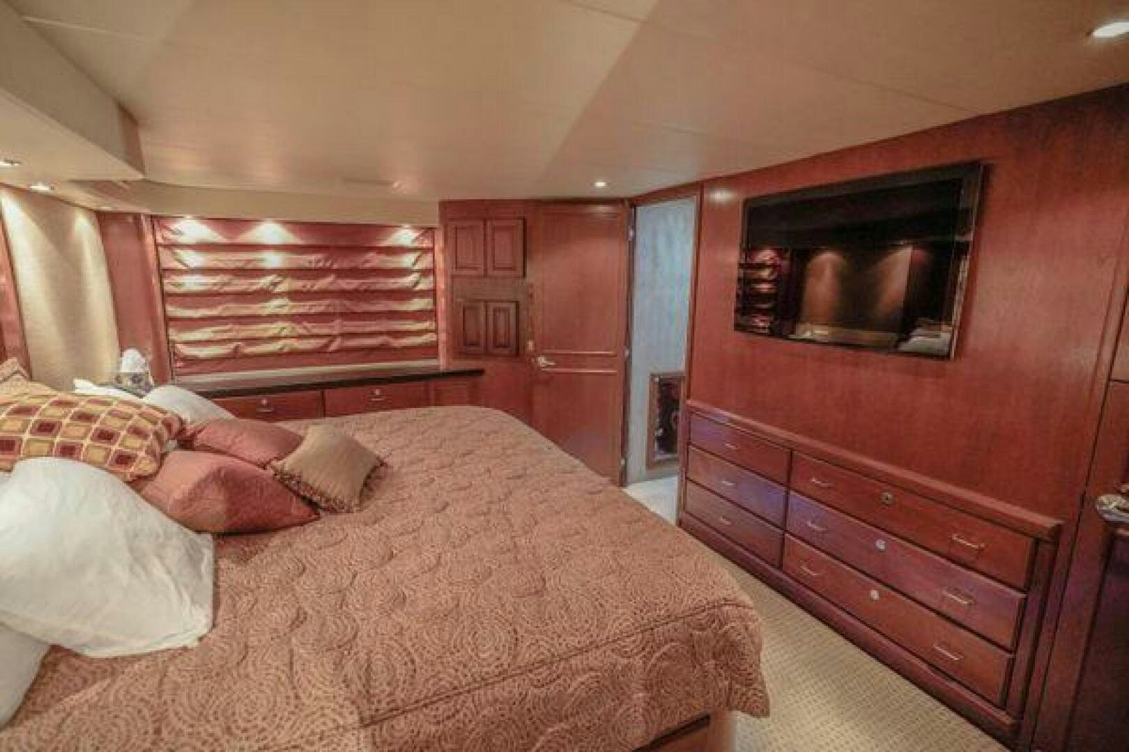 a bedroom with a bed and a television aboard POLE POSITION Yacht for Sale