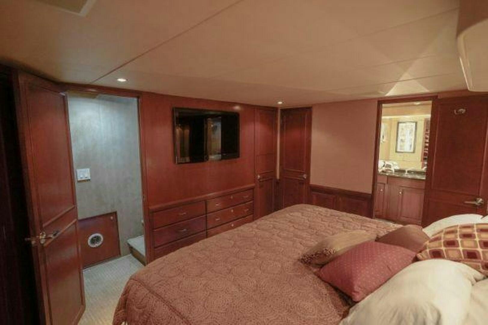 a bedroom with a bed and a dresser aboard POLE POSITION Yacht for Sale