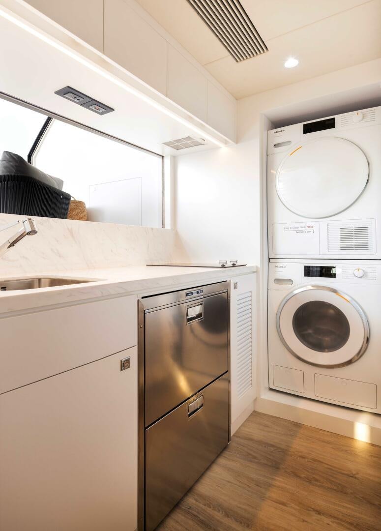 a kitchen with a washing machine and washer aboard FD80-614 Yacht for Sale