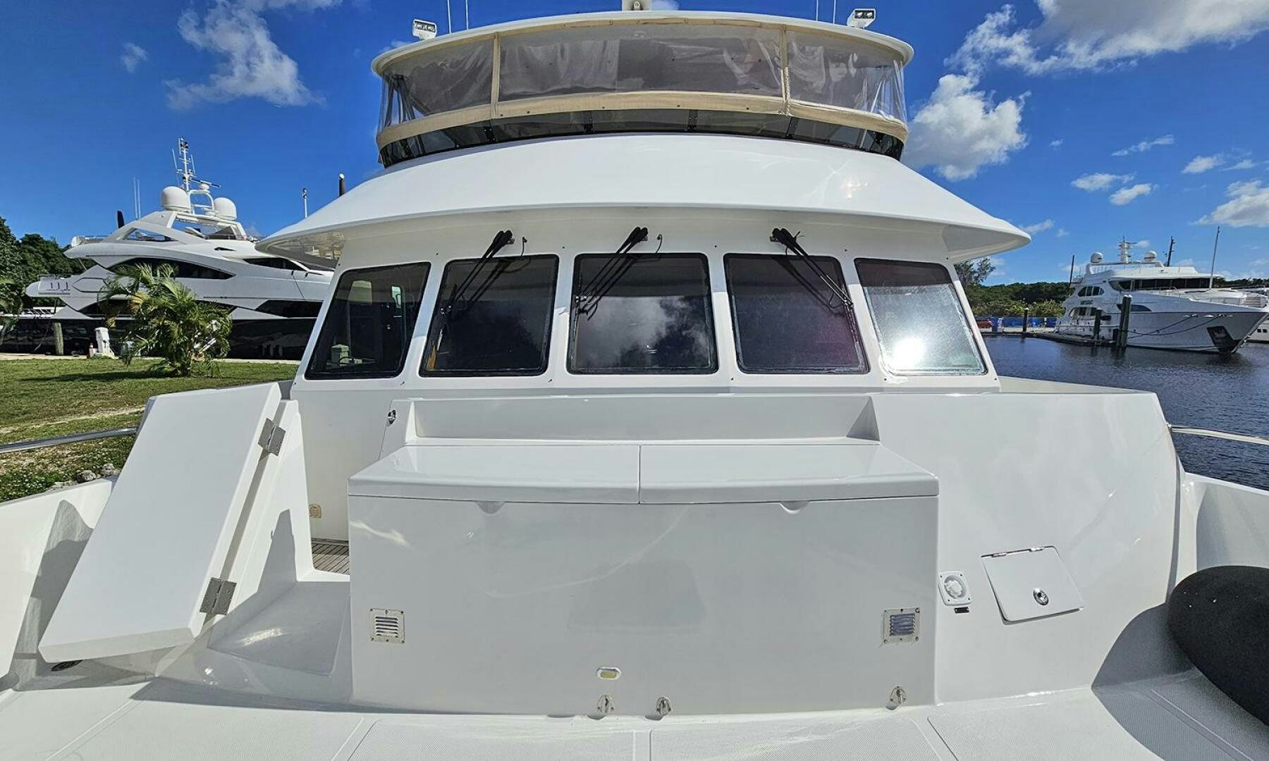 a white car parked in a parking lot with boats in the background aboard MY KIMBERLY Yacht for Sale