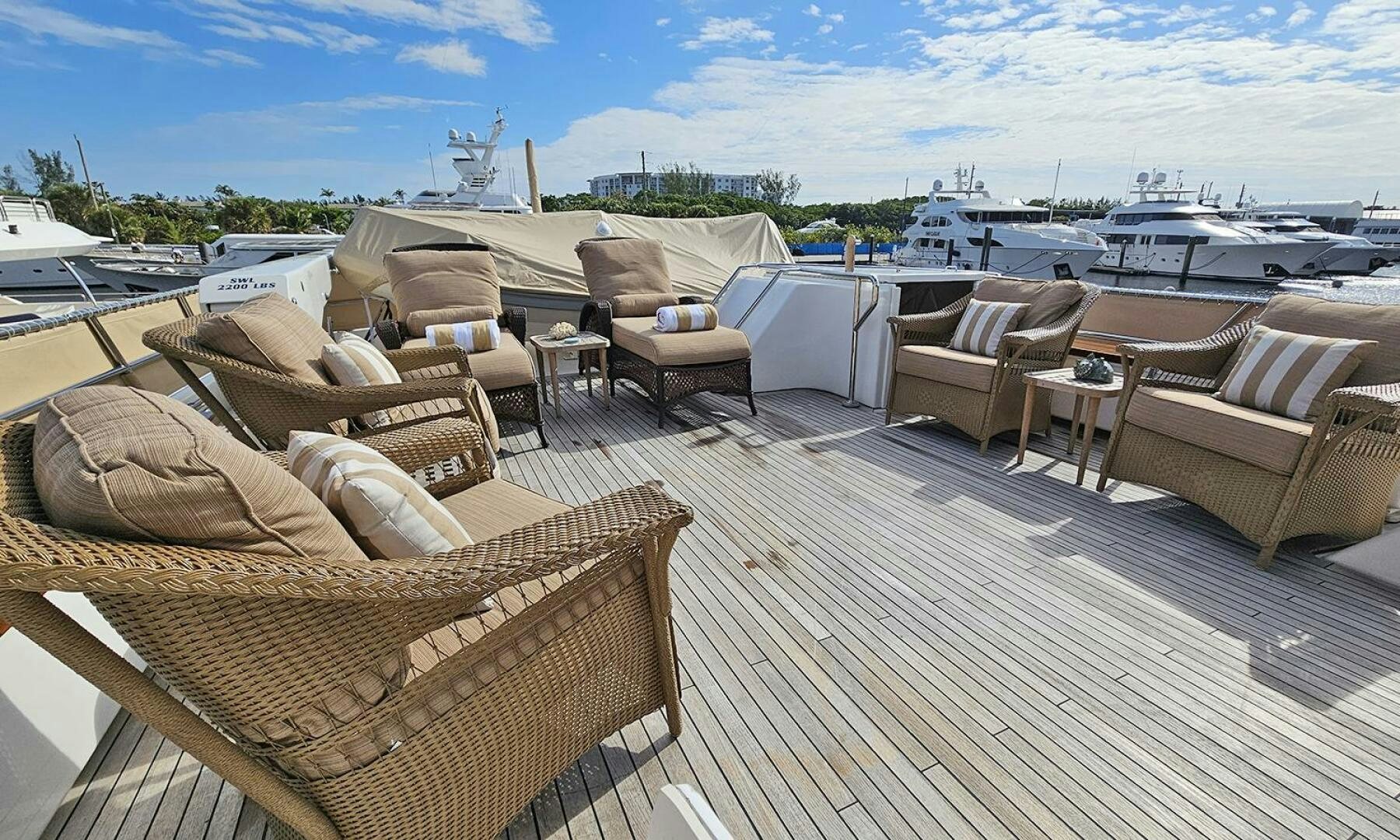 a deck with chairs and a boat in the background aboard MY KIMBERLY Yacht for Sale