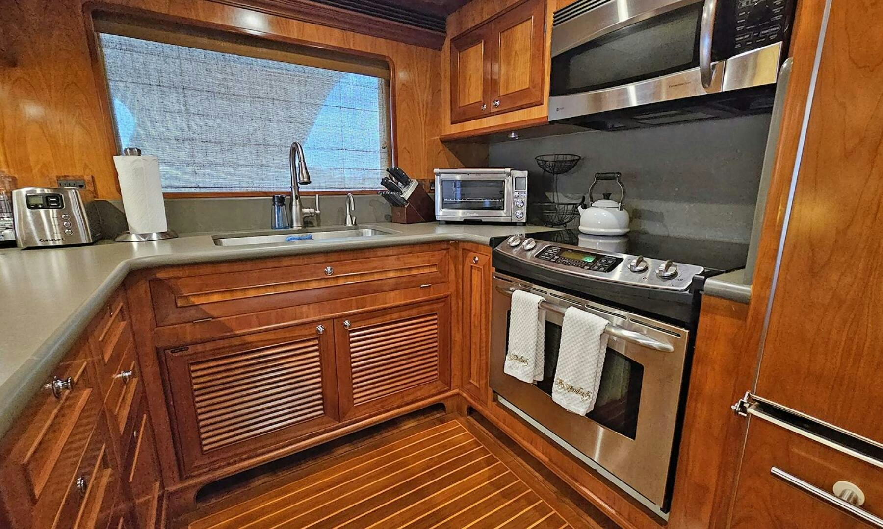 a kitchen with wooden cabinets aboard MY KIMBERLY Yacht for Sale