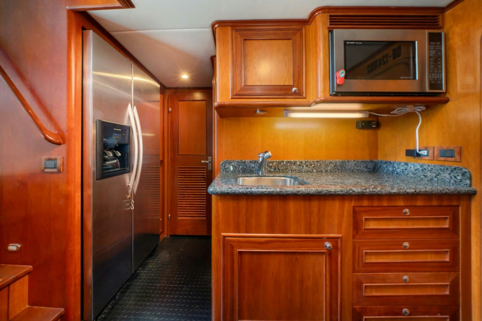 a kitchen with wooden cabinets aboard BAD-LAD Yacht for Sale